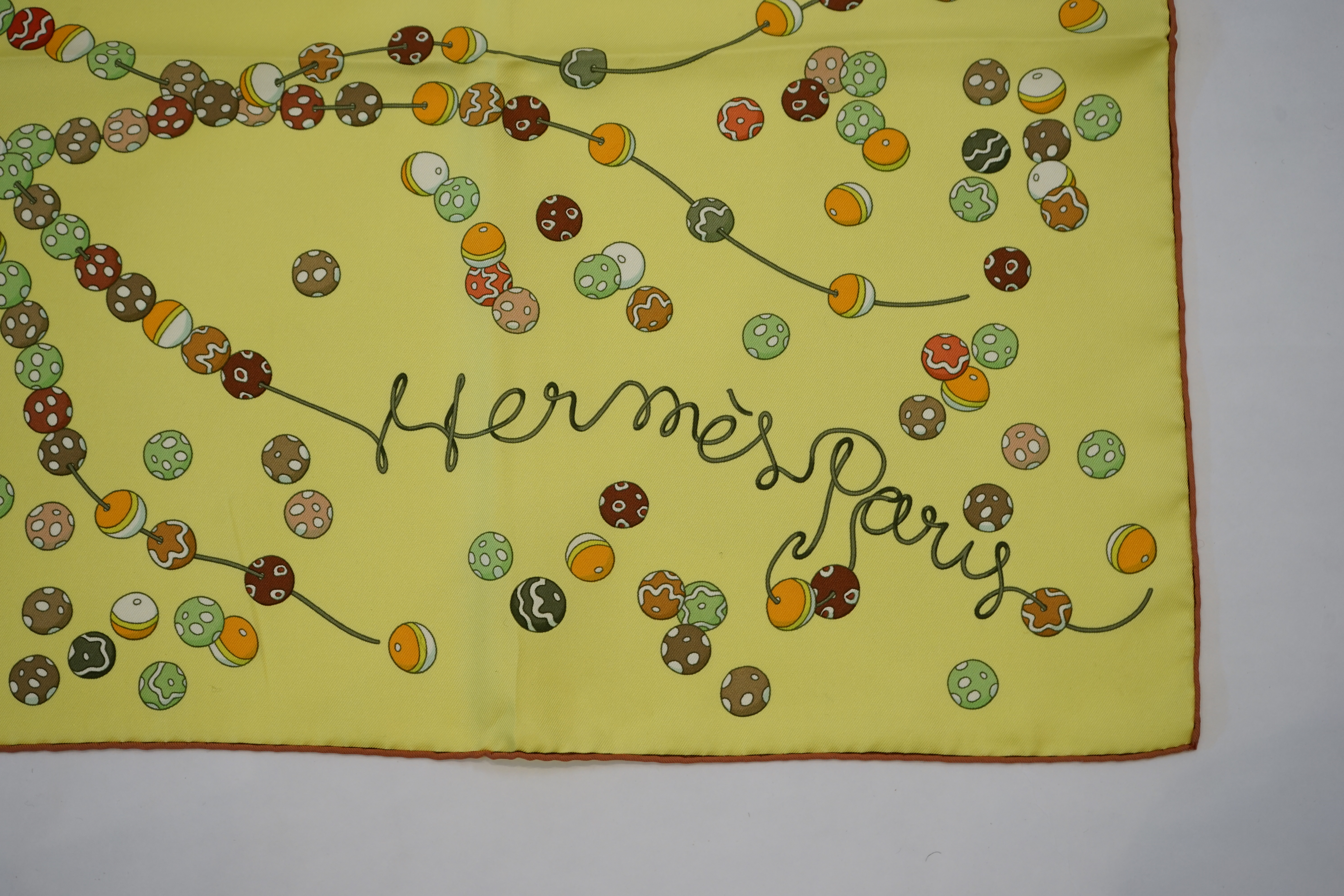 A yellow Hermès 'Dancing Pearls' silk scarf designed by Virginie Jamin, 90cm x 90cm